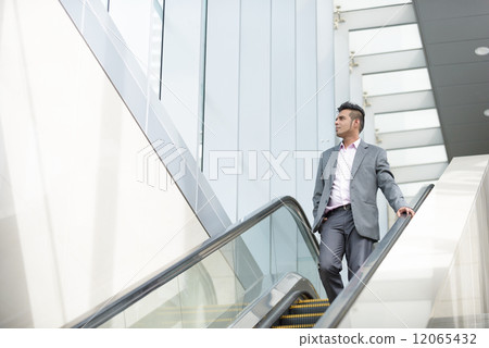 One successful young Malay business man talking the escalator One successful young Malay business man talking the escalator 12065432