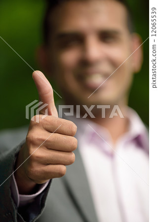 Closed up hand shot of thumbs up of successful young Malay business man Closed up hand shot of thumbs up of successful young Malay business man 12065539