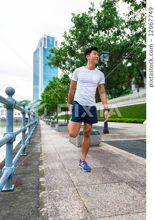 Young asian man stretching before exercise in the city 12067749