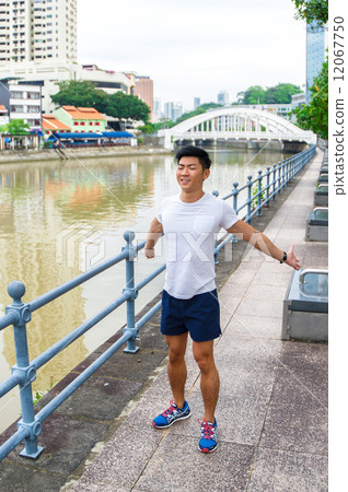 Young asian man stretching before exercise in the city Young asian man stretching before exercise in the city 12067750