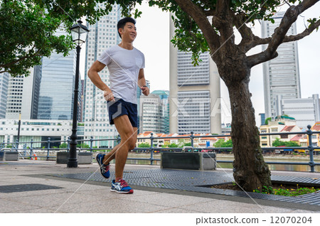 Young asian chinese man stretching / exercising outdoor in the city 12070204