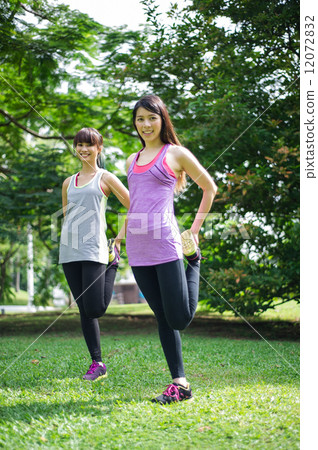 Two young beautiful asian ladies exercising / doing yoga in the park 12072832