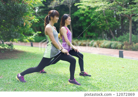 Two young beautiful asian women doing yoga in the outdoor garden 12072869