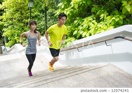 A young asian couple working out through climbing the stairways outdoor 12074241