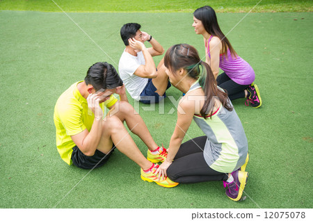 Two groups of young Asian couple helping each other to warm up before an execise in the outdoor park Two groups of young Asian couple helping each other to warm up before an execise in the outdoor park 12075078