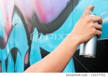 Hand holding spray paint on the wall graffiti. Hand holding spray paint on the wall graffiti. 12077781