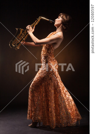 Sexual young woman posing with saxophone at studio 12080597