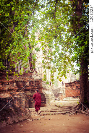 Buddhist monk at ancient ruins of Wat Mahathat. Thailand Buddhist monk at ancient ruins of Wat Mahathat. Thailand 12083284