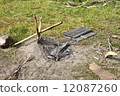 A camp fire place with slingshot for cooking and materials for kindling on a picnic 12087260