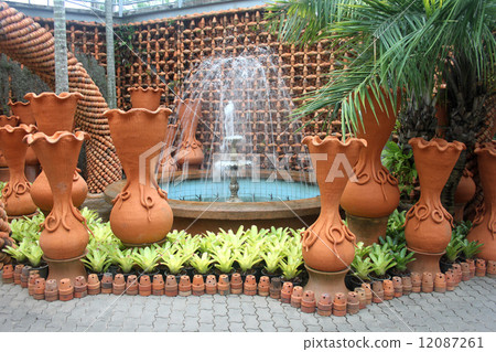 A fountain with flower pots in the Nong Nooch tropical botanic garden near Pattaya city in Thailand A fountain with flower pots in the Nong Nooch tropical botanic garden near Pattaya city in Thailand 12087261