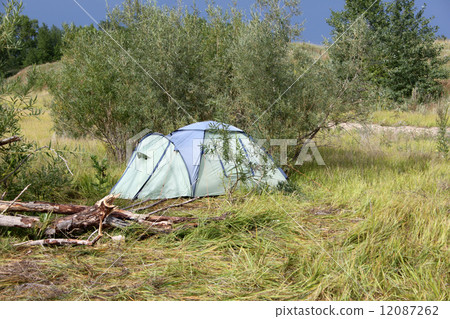 A green tent on a picnic in a forest on a sand with grass A green tent on a picnic in a forest on a sand with grass 12087262