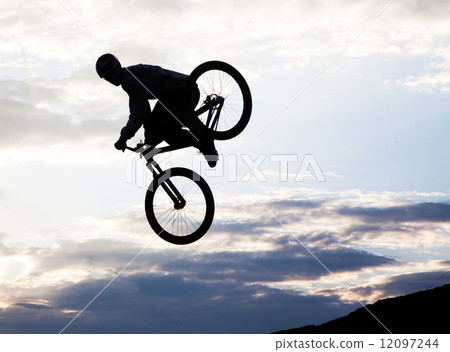 Silhouette of a man doing a jump with a bmx bike 12097244