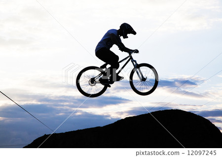 Silhouette of a man doing a jump with a bmx bike 12097245