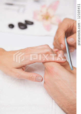 Manicurist filing a customers nails Manicurist filing a customers nails 12105451