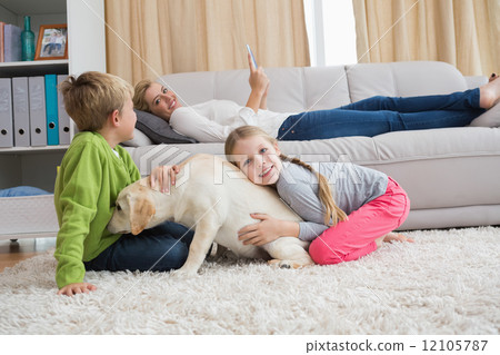 Cute silblings with their puppy on rug Cute silblings with their puppy on rug 12105787