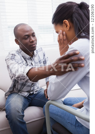 Worried woman being comforted by her therapist 12106190