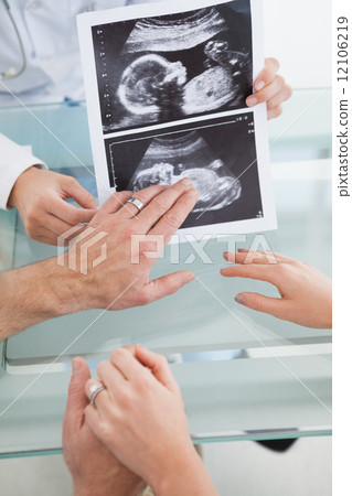 Happy couple talking to doctor Happy couple talking to doctor 12106219