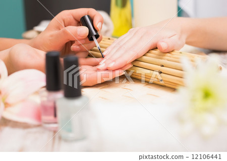 Nail technician giving customer a manicure 12106441
