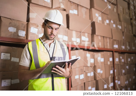 Worker with diary in warehouse Worker with diary in warehouse 12106813