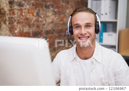 Man with headset typing on laptop Man with headset typing on laptop 12106967