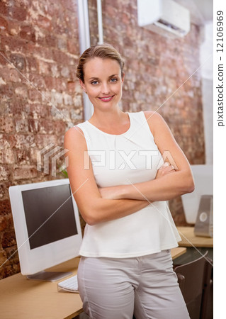 Beautiful businesswoman with arms crossed in office Beautiful businesswoman with arms crossed in office 12106969
