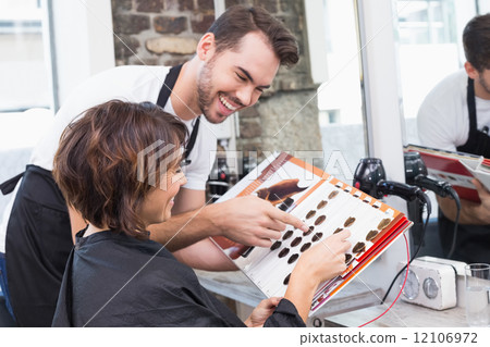 Pretty brunette picking out hair colour with stylist Pretty brunette picking out hair colour with stylist 12106972
