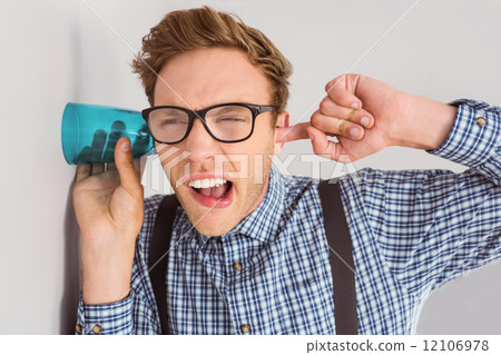Geeky businessman eavesdropping with cup Geeky businessman eavesdropping with cup 12106978