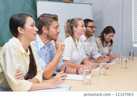 Business people taking notes at a presentation 12107065