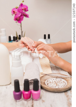 Nail technician giving customer a manicure 12107140