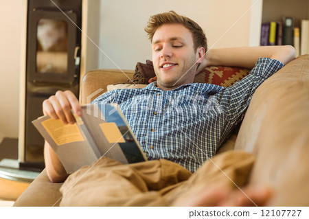 Young man reading on his couch 12107727