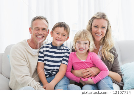 Portrait of a smiling family sitting on sofa 12107754