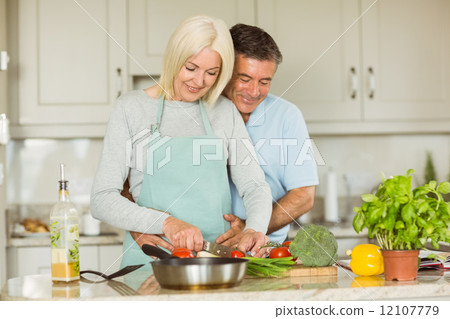 Happy mature couple making dinner together 12107779