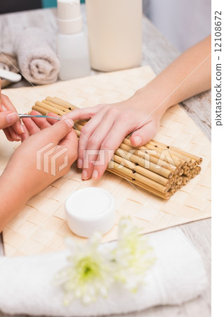 Nail technician giving customer a manicure Nail technician giving customer a manicure 12108672