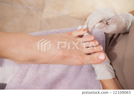 Pedicurist working on customers nails 12109063