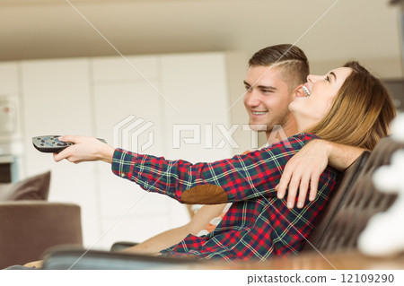 Cute couple relaxing on couch watching tv Cute couple relaxing on couch watching tv 12109290