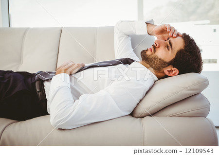 Sick businessman lying on the couch Sick businessman lying on the couch 12109543