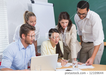 Casual business team having a meeting using laptop 12109644