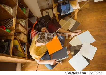 Young couple listening to vinyl records Young couple listening to vinyl records 12109770