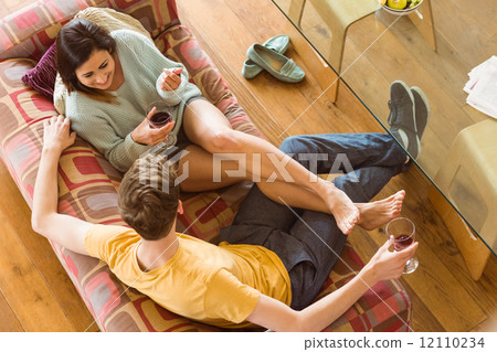 Young couple enjoying red wine on the couch Young couple enjoying red wine on the couch 12110234