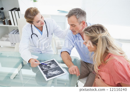 Happy couple talking to doctor Happy couple talking to doctor 12110240