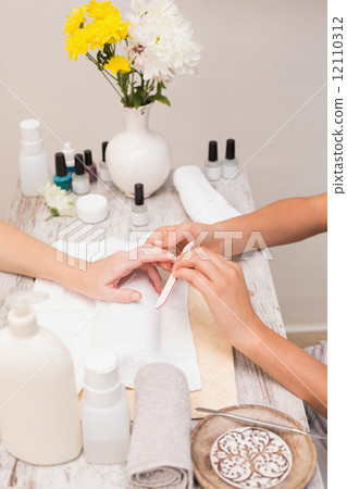 Nail technician giving customer a manicure Nail technician giving customer a manicure 12110312