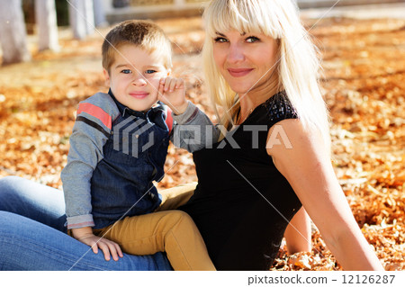 Little toddler boy in autumn park with his mother Little toddler boy in autumn park with his mother 12126287