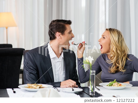Cheerful couple in a restaurant with glasses of red wine 12127222