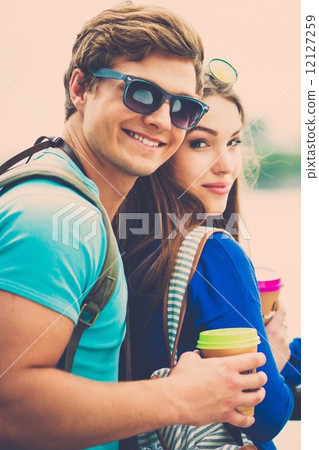 Couple tourists with map and coffee cups near river in a city 12127259