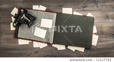 camera and album with old photos on wooden table camera and album with old photos on wooden table 12127783