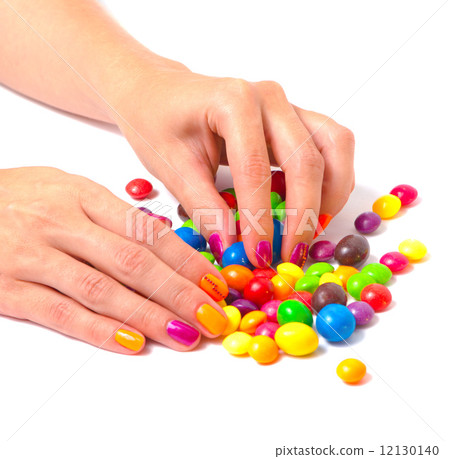 Woman's hands with bright manicure and candies 12130140