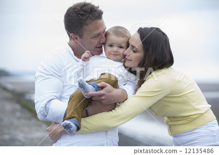 Young Family together on beach. Young Family together on beach. 12135486