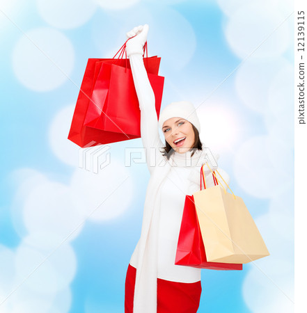 smiling young woman with red shopping bags 12139115