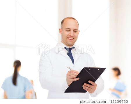 smiling male doctor with clipboard smiling male doctor with clipboard 12139460