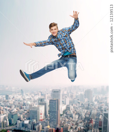 smiling young man jumping in air 12139513